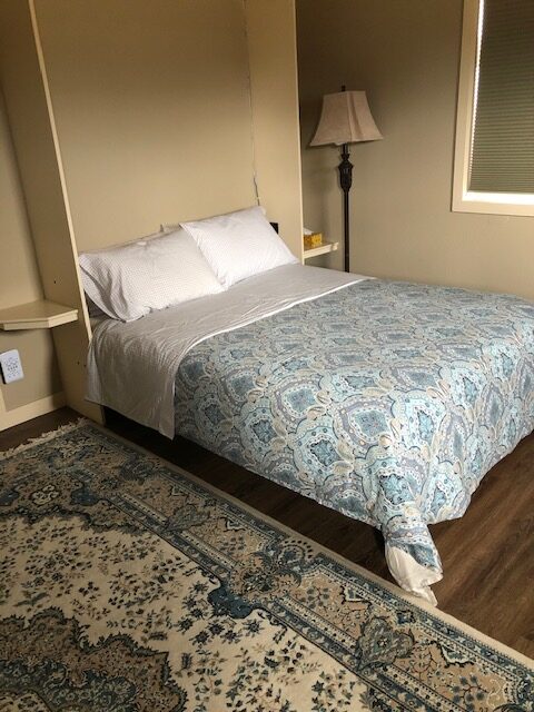 A Queen Size Bed With a Blue and White Bed Cover