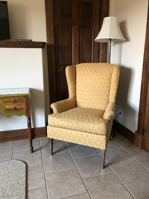 A Single Couch With a Yellow Cover